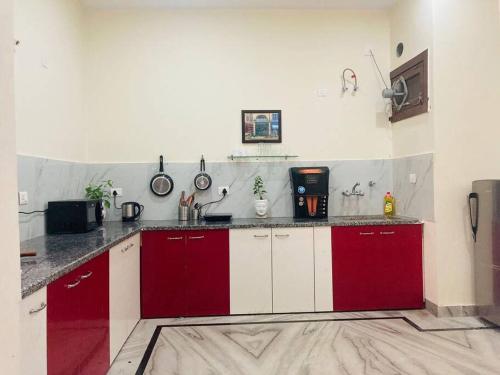 a kitchen with red and white cabinets in a room at Zoeys Homestay - 1BHK with Free Breakfast in Jammu