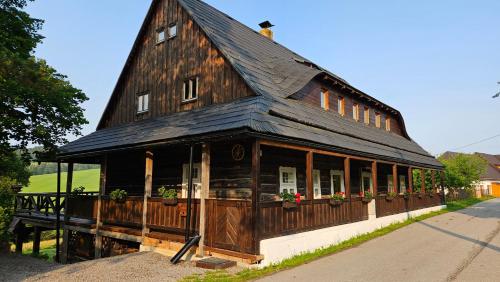 ein großes Holzgebäude mit schwarzem Dach in der Unterkunft Drevenica Borovianka in Veľké Borové