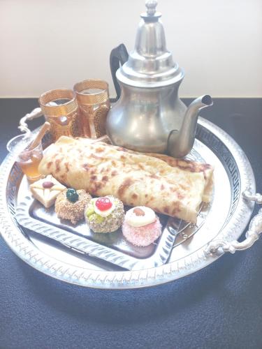 une assiette de nourriture sur une table avec une théière dans l'établissement Gîte Narbonnais avec chambre- proche des plages-Jardin-Terrasse-Parking, à Narbonne