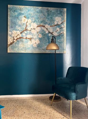 a blue room with a blue chair and a painting at Apartamentos Boutique Poniente Playa in San Antonio