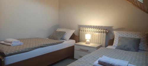 una camera con 2 letti e una lampada su un comodino di Katty-Rastoke a Slunj