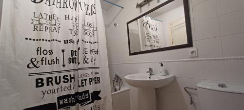 a bathroom with a sink and a toilet and a shower curtain at Adosado en Islantilla in Islantilla