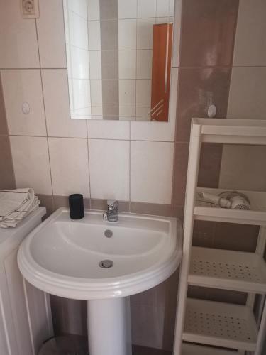 y baño con lavabo blanco y espejo. en Apartment Croatika on the Beach, en Trogir