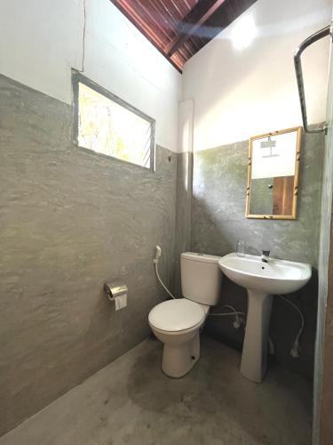 a bathroom with a toilet and a sink at Waypoint Arugam Bay in Arugam Bay