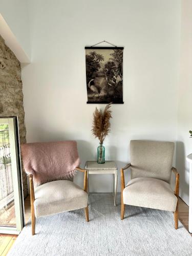 a living room with two chairs and a table at Figtrees in Margueron