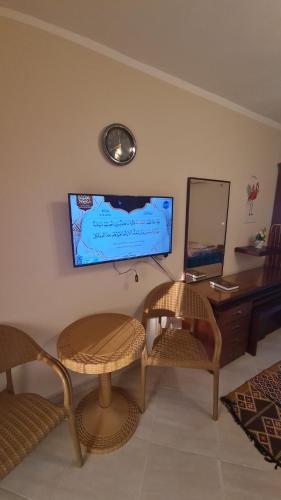 a living room with two chairs and a tv on the wall at استوديو فندقي مكيف وفيو رائع in Borg El Arab