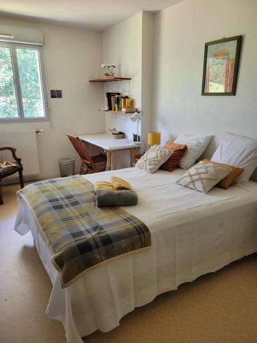 Cette chambre comprend un grand lit blanc et une table. dans l'établissement Appartement pechDavid SUD, à Toulouse