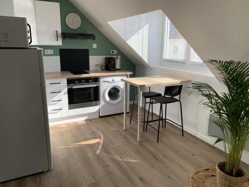 a kitchen with a table and a stove and a microwave at Chez Aline & Seb in Boulogne-sur-Mer