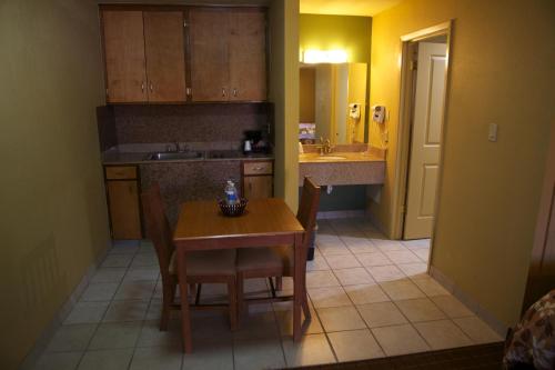 a kitchen with a table and chairs and a sink at Coach Light Inn in Brenham