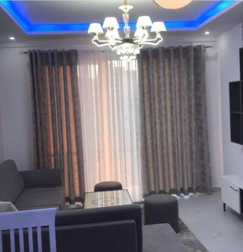 - un salon avec un canapé et un lustre dans l'établissement Best Apartments, à Elbasan