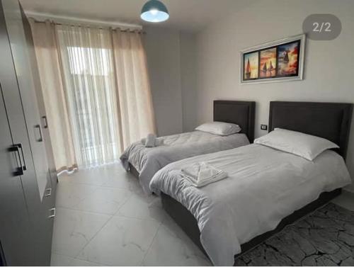 - 2 lits dans une chambre avec fenêtre dans l'établissement Best Apartments, à Elbasan