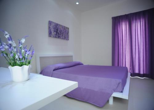 a bedroom with a purple bed and purple curtains at Isola Verde Agriturismo in Carovigno