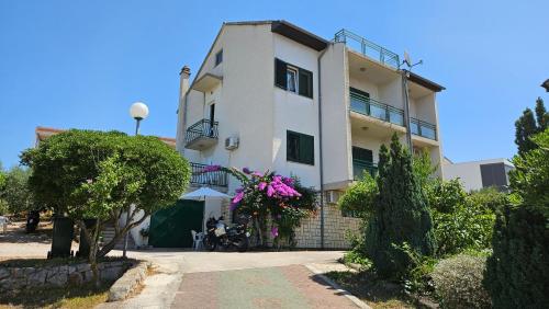 een groot wit gebouw met bloemen ervoor bij Solaris Apartments in Šibenik