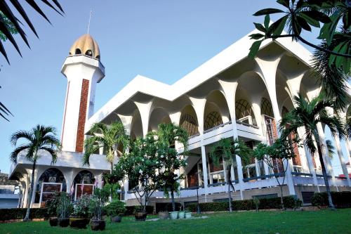 budynek z wieżą zegarową i palmami w obiekcie DeliZia de Villa เดลิเซีย เดอ วิลล่า w mieście Satun
