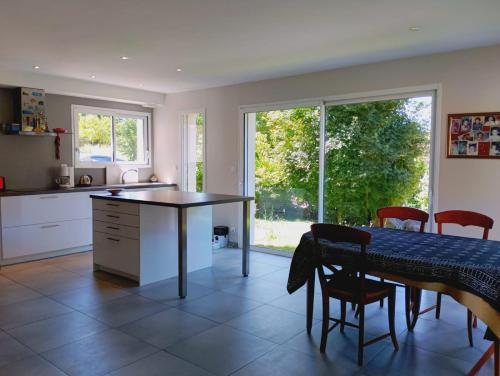 une cuisine avec une table et des chaises ainsi qu'une salle à manger dans l'établissement 15mn grenoble-30mn vercors wifi gratuit-6personnes vue vercors, à Fontanil-Cornillon