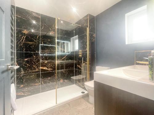 a bathroom with a shower and a toilet and a sink at Farne Island rooms in Seahouses