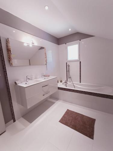 une salle de bain blanche avec une baignoire et un lavabo dans l'établissement 15mn grenoble-30mn vercors wifi gratuit-6personnes vue vercors, à Fontanil-Cornillon