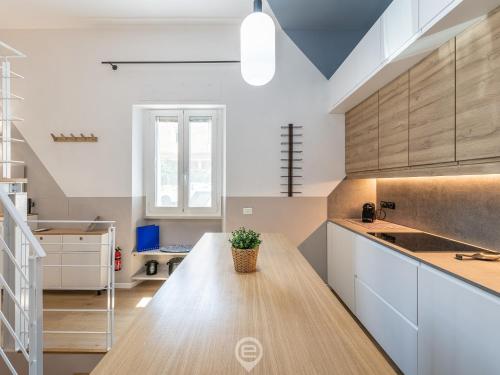 a kitchen with white cabinets and a wooden counter top at Is Arenas Biancas Apartment in Teulada