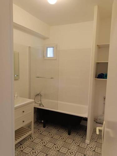 La salle de bains blanche est pourvue d'une douche et d'un lavabo. dans l'établissement La garçonnière de Gégé, à Tournus