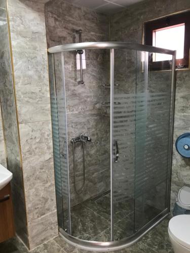 a shower with a glass door in a bathroom at Danis Motel in Uzungöl