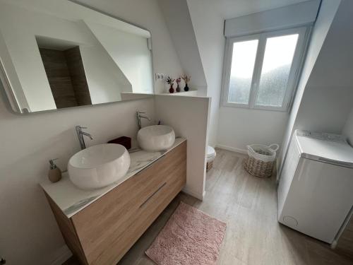 une salle de bain avec un lavabo et un miroir dans l'établissement La maison sur la Ria _ 8 voyageurs, à Plouhinec