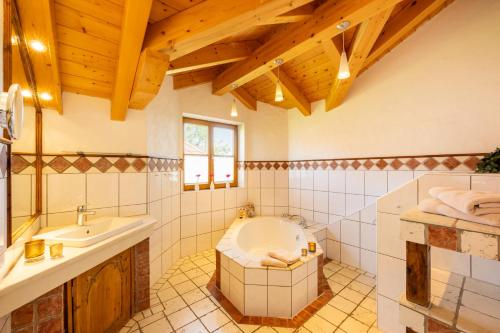 uma casa de banho com uma banheira e um lavatório em Ferienhaus Weinklause am Plattenbichl em Oberstdorf
