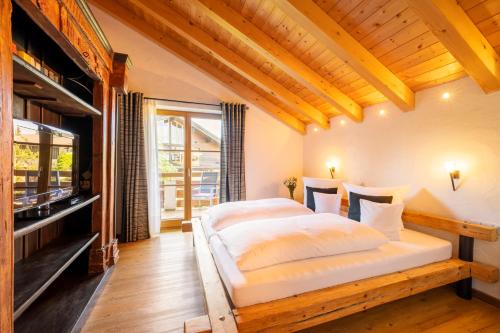 1 Schlafzimmer mit 2 Betten und einem Flachbild-TV in der Unterkunft Ferienhaus Weinklause am Plattenbichl in Oberstdorf