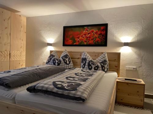 a bedroom with a bed with a painting on the wall at Ferienhaus Perwolff in Eisenberg an der Pinka