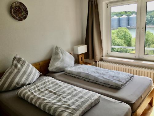 two beds sitting in a room with a window at Ostseenahes Traumhaus am Kiel-Kanal in Schleswig-Holstein - Zum Ostseestrand in zehn Minuten in Altenholz