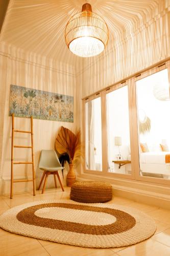 a room with a rug and a chair and a window at Bella Bali in Uluwatu