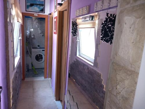a hallway of a house with a window and a washing machine at S Type Apartment in Split