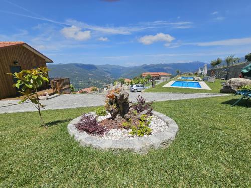 a flower bed in the grass next to a pool at Casa do Iteiro in Caniçada