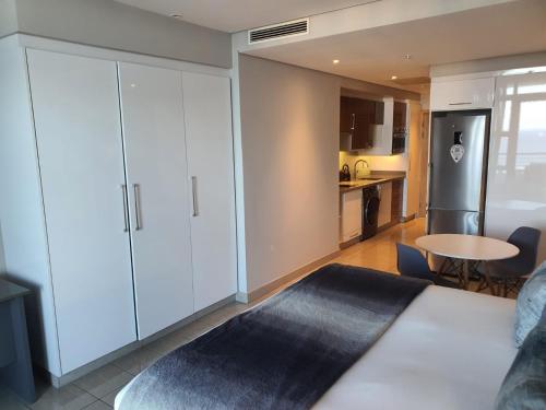 een woonkamer met een grote witte kast en een keuken bij The Pearls Luxury Studio Apartments - Full Sea View in Durban