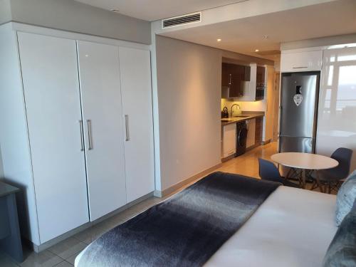 Una sala de estar con un gran armario blanco y una cocina. en Pearls Full Sea View Luxury Studio - Self Catering, en Durban