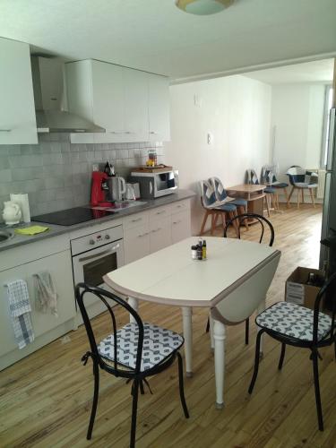 une cuisine avec une table et des chaises dans une cuisine dans l'établissement gîte 4 chambres à Cognac, à Cognac
