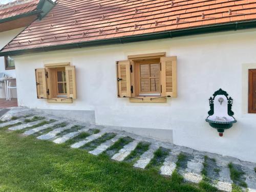 a white house with two windows and a staircase at Ferienhaus Perwolff in Eisenberg an der Pinka