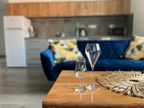 two wine glasses sitting on a coffee table in a living room at Apartmány Catalina in Nesvady