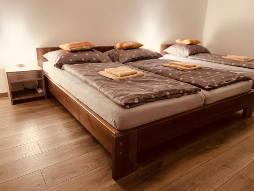 two twin beds in a room with wooden floors at Apartmány Catalina in Nesvady
