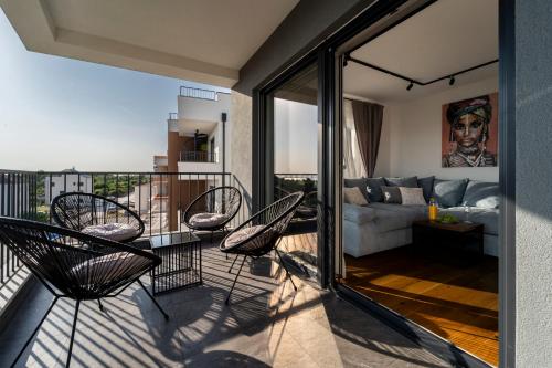 a balcony with chairs and a living room at Apartment Skyline Retreat in Zadar