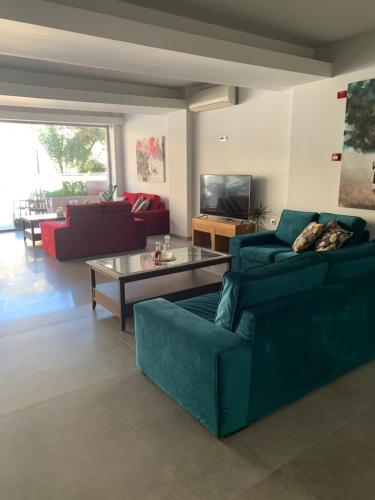 ein Wohnzimmer mit einem blauen Sofa und einem Tisch in der Unterkunft Petra Hotel in Agia Galini