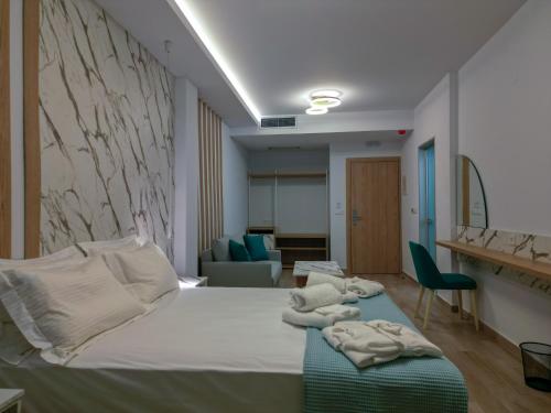 ein Hotelzimmer mit einem Bett mit Handtüchern darauf in der Unterkunft Electra Suites in Samothráki