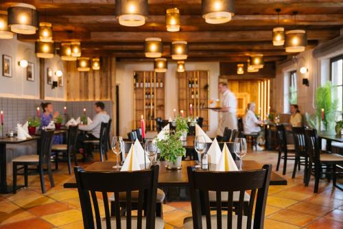 a restaurant with people sitting at tables in a room at MONDI Resort und Chalet Oberstaufen in Oberstaufen