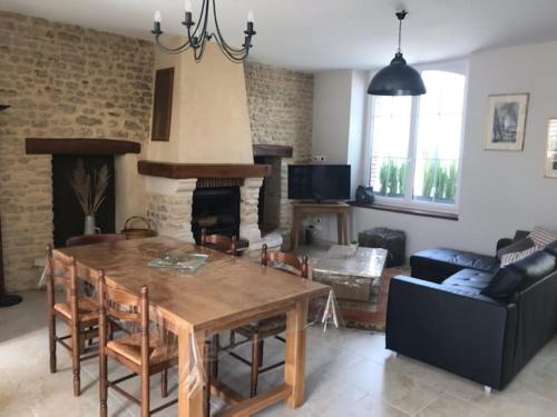 a living room with a wooden table and a fireplace at Gite Pomme de pin in Almenêches
