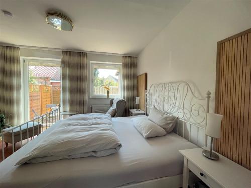 a bedroom with a large white bed and a balcony at Idyllisches Wohnen in Bad Bramstedt in Bad Bramstedt