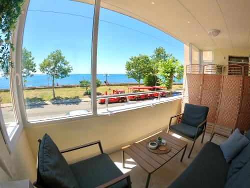 a living room with a large window with a view of the ocean at Sunset Yavorov Pomorie in Pomorie