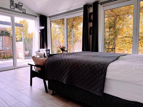 a bedroom with a bed and a large window at Coast Holiday Appartements in Dirkshorn
