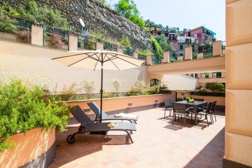 une terrasse avec une table, des chaises et un parasol dans l'établissement Elios by PortofinoHomes, à Portofino