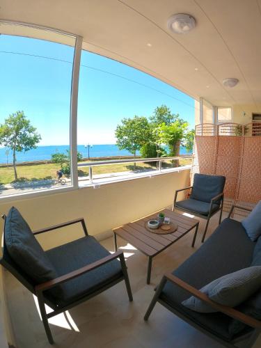 a living room with chairs and a table and a view of the ocean at Sunset Yavorov Pomorie in Pomorie
