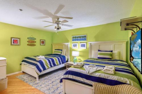 sypialnia z 2 łóżkami i wentylatorem sufitowym w obiekcie Oceanside 302 w mieście Clearwater Beach