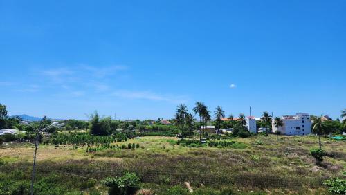 a field with trees and buildings in the distance at Lacovy Home Hội An in Hoi An